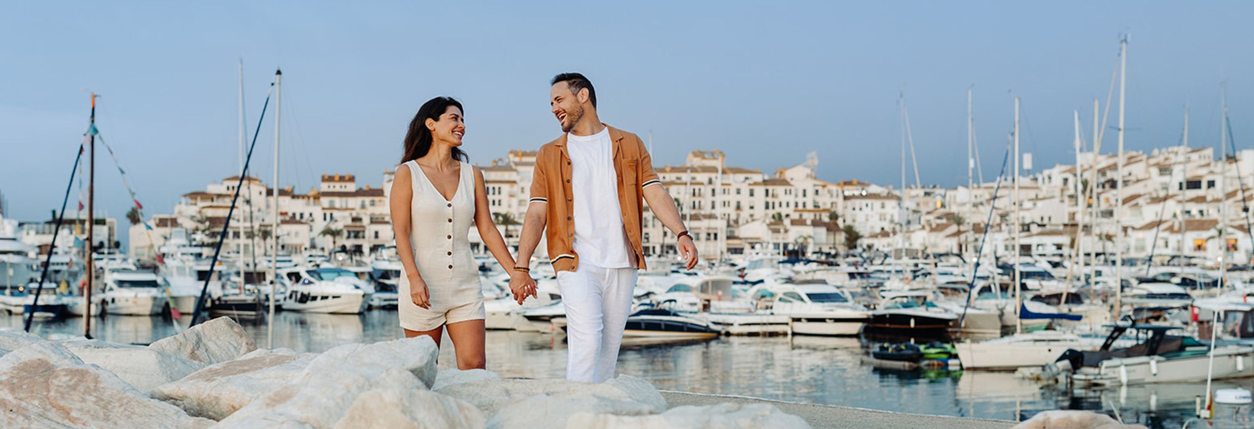 Couple holding hands walking in a marina
